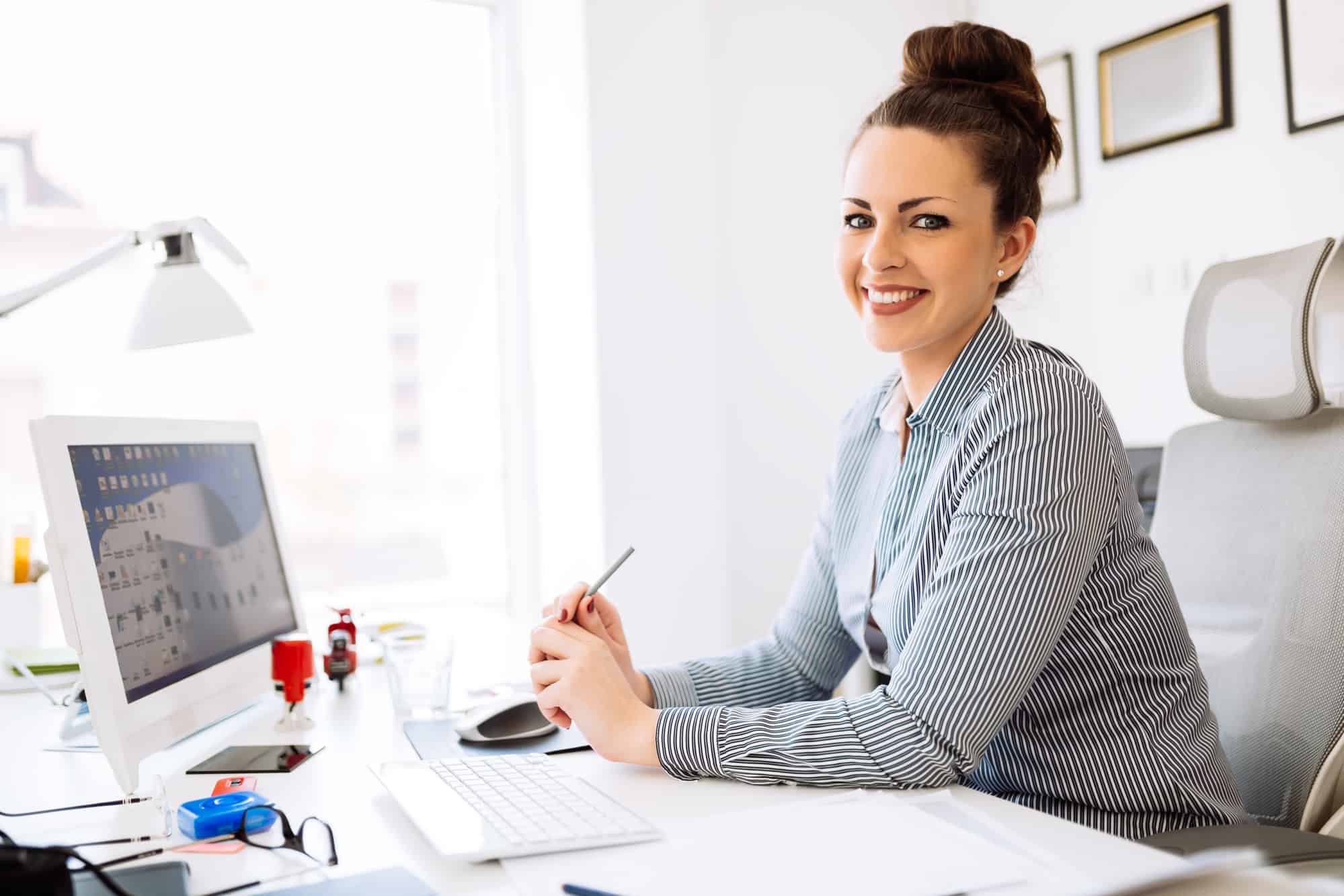  A smiling accountant sits at her desk, ready to help a freelancer manage their finances.